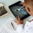 Crop African American student studying craters of moon on tablet at observatory